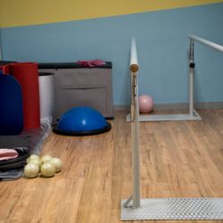 Sala de barras paralelas y colchonetas para ejercicios en suelo